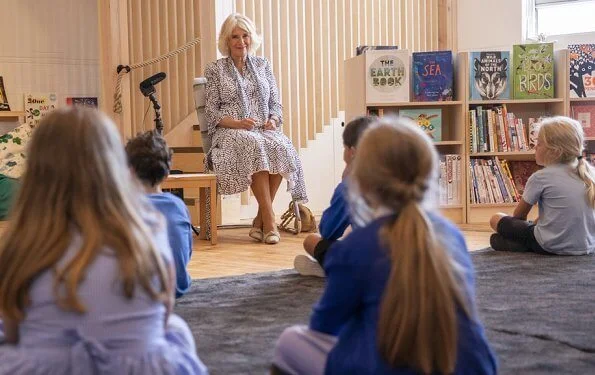 The Duchess of Cornwall is patron of The National Literacy Trust. The duchess wore a printed silk summer midi dress. beige pumps and bag
