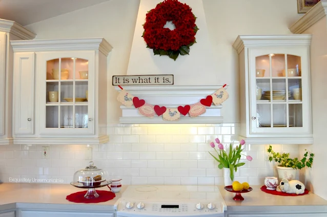 Kitchen decorated for Valentines Day with card banner hanging on stove hood