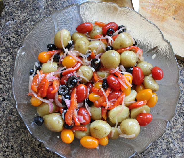 Food Lust People Love: Pumped up potato salad combines new potatoes with charred red peppers, tomatoes, olives, feta and basil for a wonderful summer salad.