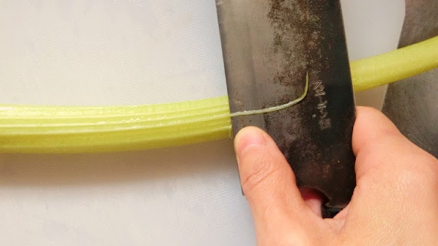 セルリーの筋取りは、葉の方から茎に向かって包丁を滑らせるように取り除く。