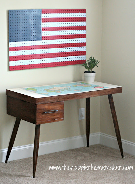 American flag pegboard over a desk with a small plant