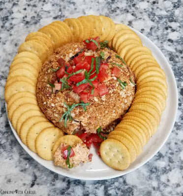 Bacon and bruschetta get all cozy together is a fun cheese ball that is a perfect summer appetizer. bacon bruschetta cheese ball spread on a cracker