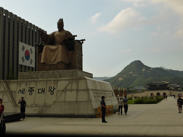 Estatua del Rey Sejong El Grande con el palacio y las montañas al fondo Estatua del Rey Sejong El Grande con el palacio y las montañas al fondo