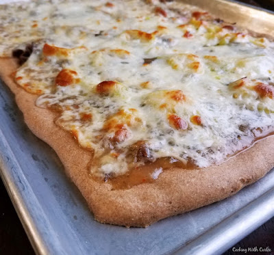 All of the flavors and textures of a delicious Italian beef sandwich in pizza form. It is full of flavor and so much fun to eat! corner of freshly baked pizza on sheet pan