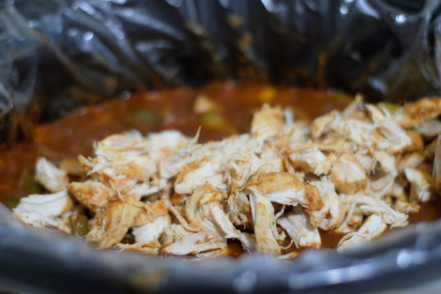 The shredded chicken added to the crockpot.  