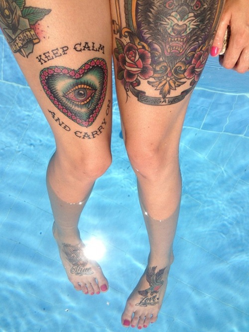 chica bañandose en una piscina que lleva tatuajes en las piernas estilo old school