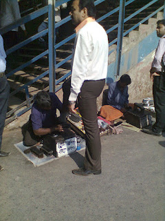 Shoe shine man polishing shoes at railway station, andheri bandra cst central railway shoe polishers