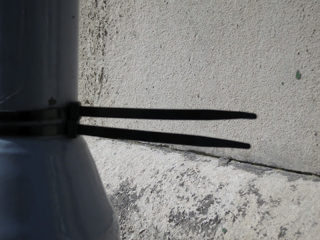 Plastic twist tied to a post by a wall