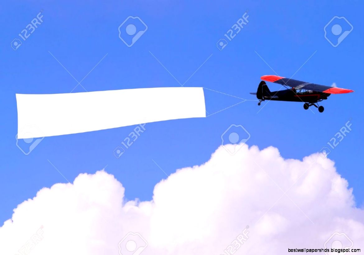 An Airplane Flying Through The Sky Pulling A Blank White Banner