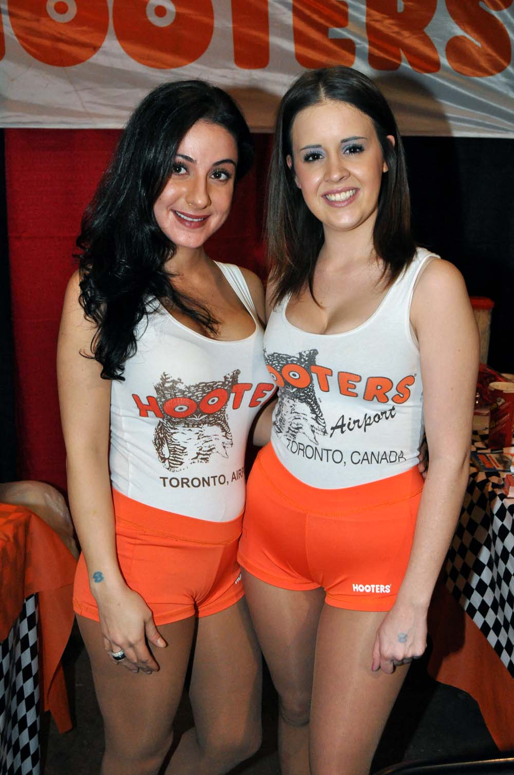 Hooters girls in full orange short uniform.