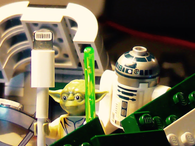 Lego yoda holding a wire next to a lego r2d2