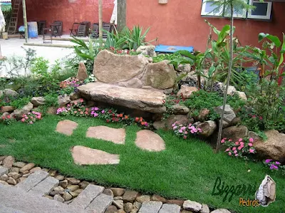 Pisadeira de pedra no jardim, com pedra moledo tipo chapada, com tamanhos variados, de 40 cm a 70 cm.