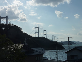 The Kurushima-Kaikyo bridge stretching into the distance as seen Oshima island on the Shimanami Kaido. Houses in the foreground