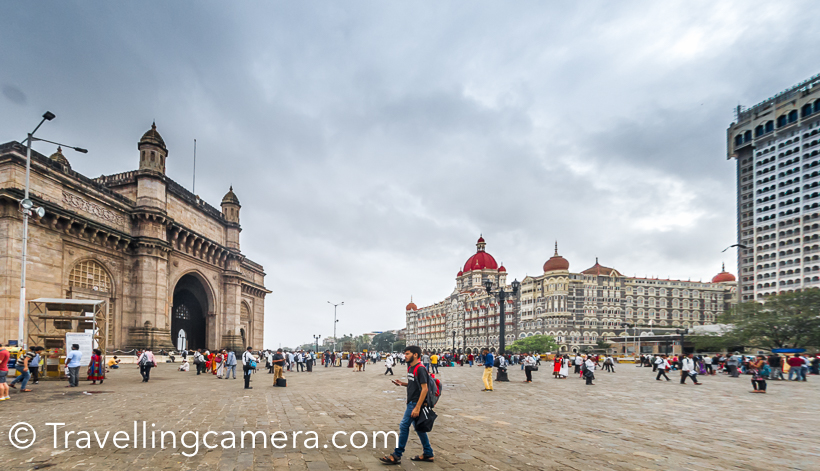Few weeks back I was in Mumbai for 2 days and had great company to explore this beautiful town in monsoons. This Photo Journey shares about Gateway of India, which is one of the most visited places in Mumbai and things to do around it. Gateway of India is surrounded by some of the best architectures in Mumbai and few popular restaurants & cafes.And if you are visiting Gateway of India, it makes sense to also know about other interesting things to do around it. So this post also talks about main things to do around Gateway of India and the famous Taj Mahal Palace Hotel.Gateway of India is located on waterfront and was built in 20th century. This beautiful architecture is in south Delhi. I was staying near Airport and it took 1.5 hrs to reach Gateway of India from our hotel. This is most visited place in Mumbai city.If you like knowing or photographing architecture, there are some beautiful buildings around Gateway of India. I highly recommend to walk around Gateway of India on foot and explore some of the beautiful buildings around the famous Taj Mahal Palace hotel.There is also a street behind Taj Mahal Palace hotel for people who love to do some shopping. There are lot of kiosks selling artificial jewelry. I didn't do any shopping here, but it seemed that lot of negotiation happens in these street, which is not very surprising.There are lot of beautiful buildings all around. It was my first visit to Mumbai and the city lot of old structures surrounded by high-rise apartments.Here is a photograph of the famous Leopold Cafe & Bar . I am sure you would have heard of this name. If it's getting a little difficult, let me help in reminding that cafe was impacted by terror attack in 2008. I loved these windows. This whole street behind famous Taj Mahala Palace Hotel has beautiful windows. I wish I had more time to observe them in a better way and capture through my Travellingcamera.I know traffic of Mumbai is talked about a lot, but I must say that traffic police does a great job. And most of the drivers are quite disciplined. Lack of these 2 would certainly convert the whole thing into chaos. We drove from Sahar to Colaba in a cab at around 3pm and it took us 1.5 hrs. During evening it may take somewhere around 2.5 hrs to 3 hrs (told by our hotel staff).Above is photograph of famous Taj Mahal Palace Hotel and you can see horse carts in front of it. Tourists can have a tour around this place in these horse carts.When I pointed my camera towards this building, this couple was wondering what am I clicking here. Notice the smile on the face of this boy and girl is looking back to figure out my subject :)Group of photographer friends around Gateway of India. It was time to relax a bit. These guys click photographs of tourists around Gateway of India and hand-over the printouts in few minutes. It's certainly a very tiring job to be on feet all the day, creating beautiful memories for tourists and try best to deliver good quality.