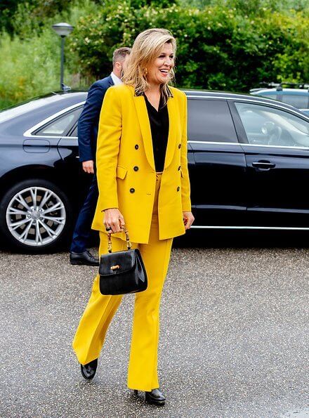 Queen Maxima wore a yellow blazer and trousers from Zara, Cartier gold bamboo earrings, carries Susan Gail bamboo handle handbag