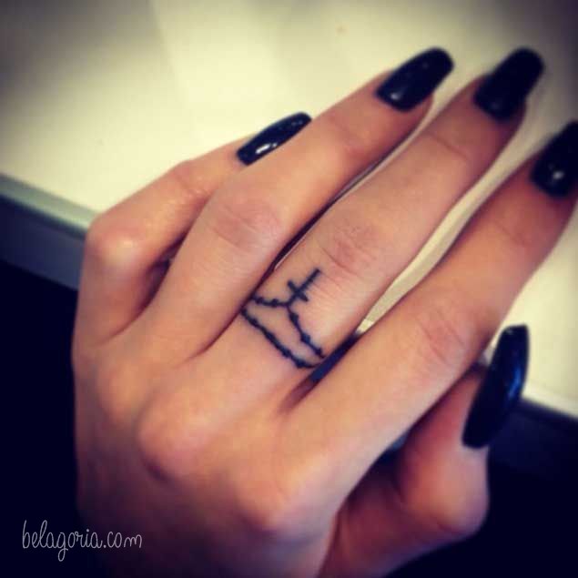 Un tatuaje en los dedos de un crucifijo