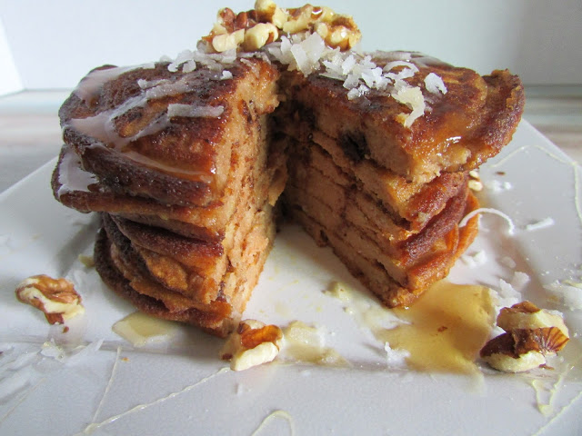 Stack of pumpkin pancakes on a plate with a bite missing 