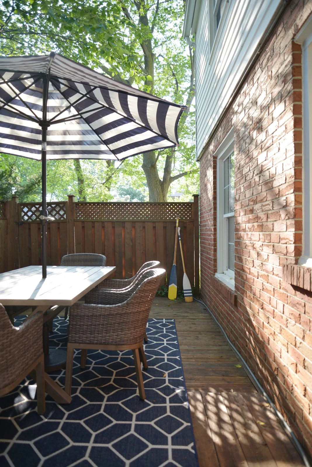 blue and white outdoor decor, striped patio umbrella, geometric outdoor rug
