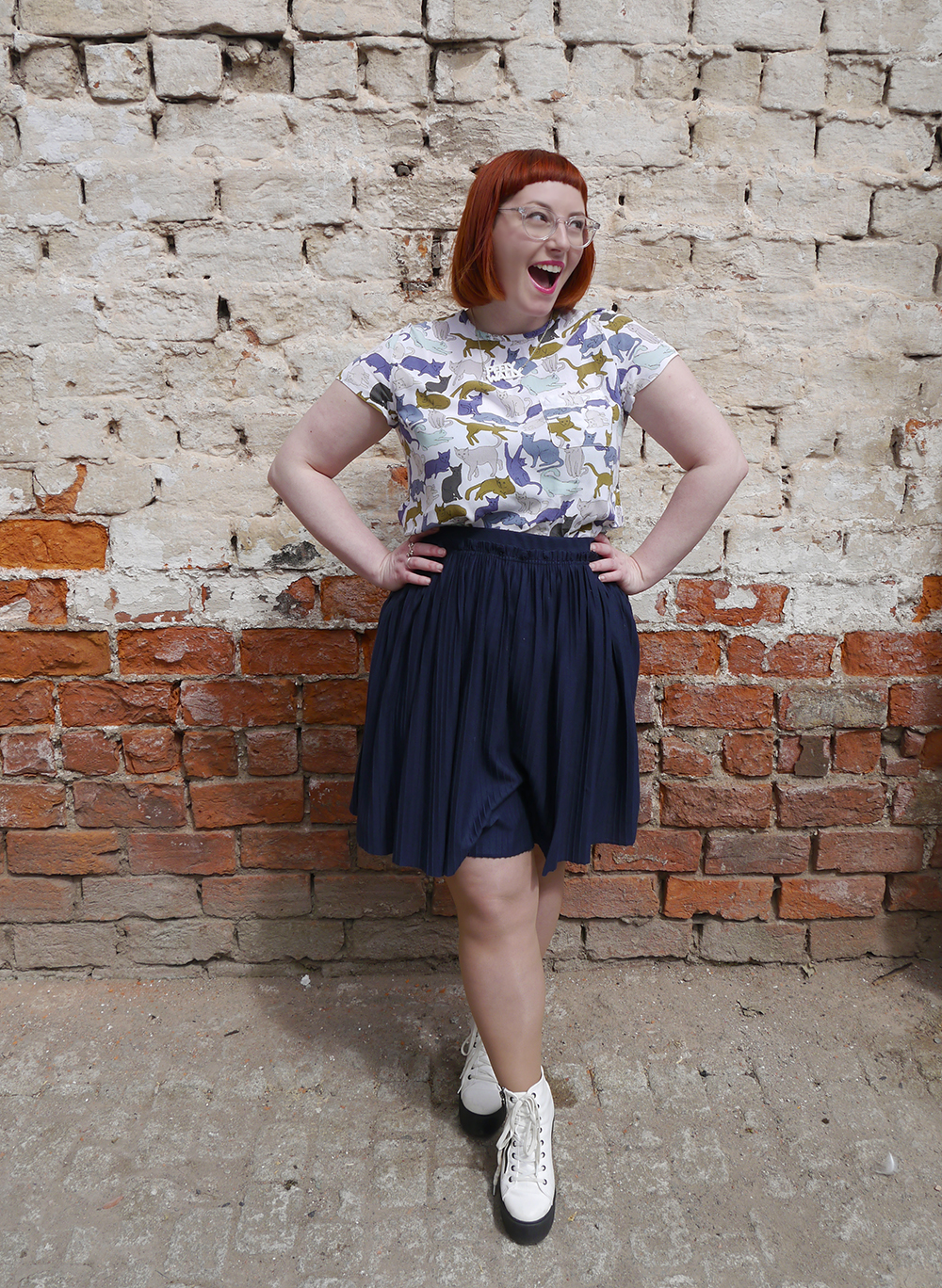 What Helen Wore: Tea Green Concept Atelier what Helen wore, red head, See with Iolla, Iolla clear glasses, clear spectacles, Scottish blogger, scottish fashion blogger, Dundee blogger, Dundee event, Dundee, cat lady, crazy cat lady outfit, cat top, H&M outfit, blue skirt, pleated navy skirt, charity shop shoes, white lace up boots, pink blazer, Lucky Dip Club pin, Kate Rowland wooden brooch, Bonnie Bling necklace, Scottish slang necklace, peely wally necklace, Scottish street style, brick wall background, cat print top
