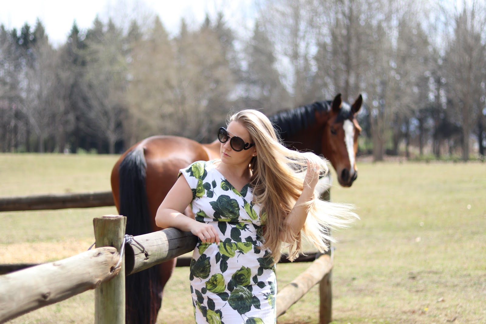 Katie Heath wearing green and white dress with a horse at Ardmore Ceramics, South Africa
