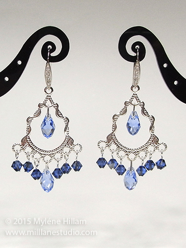 Silver filigree chandelier earrings with dangling blue crystals