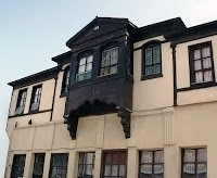 Eski ahşap bir evin siyah renkli pencereli cumbası