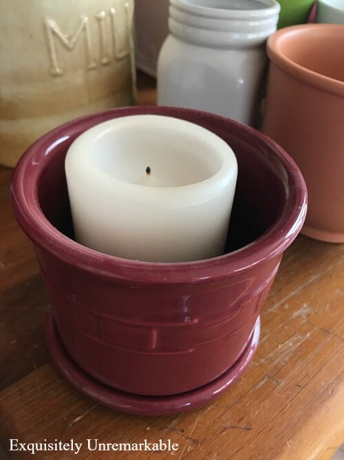 An Old red Candle Holder with half burned candle inside