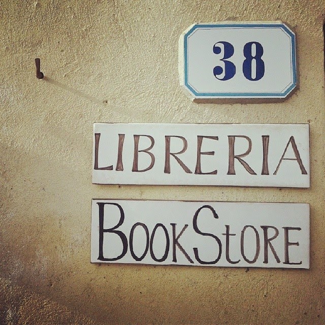 'Libreria' and 'Bookstore' signs on the wall of a bookstore in the Val d'Orcia