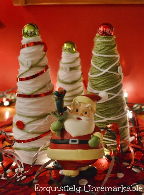 Christmas yarn trees with Santa figure standing in front of them