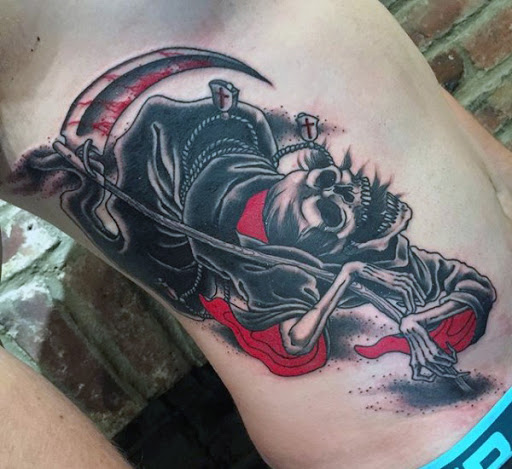 Grim Reaper tatuagem com um vermelho brilhante tinta. A tinta vermelha sobre a tatuagem representa tanto sangue e o manto do reaper, significando a morte física e espiritual ao mesmo tempo.