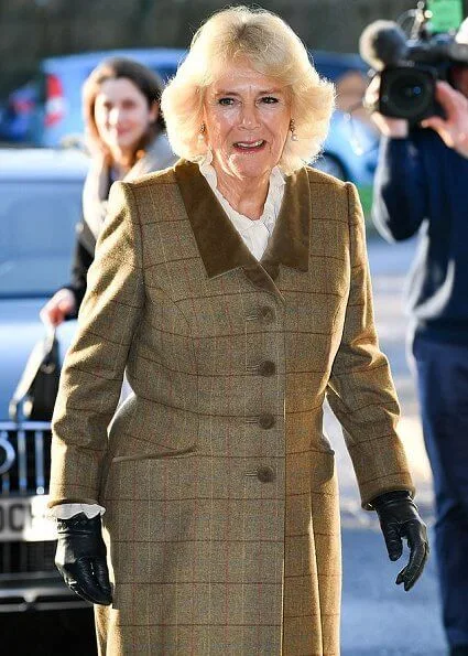Camilla arrived at the hospice in a smart brown tweed two-piece, pairing the outfit with a simple cream blouse with over-the-knee boots