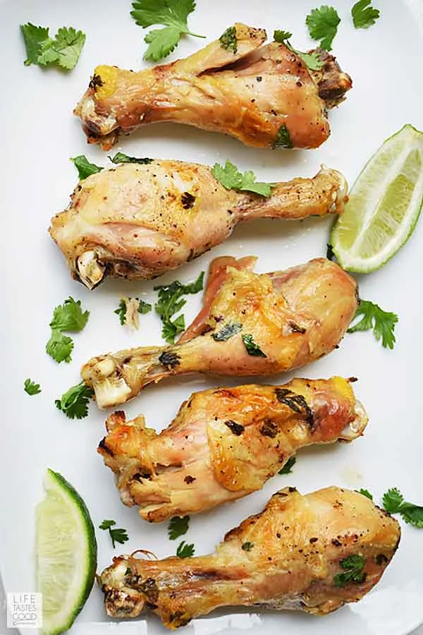 Slow Cooker Cilantro Lime Chicken on white serving tray garnished with cilantro and lime wedges