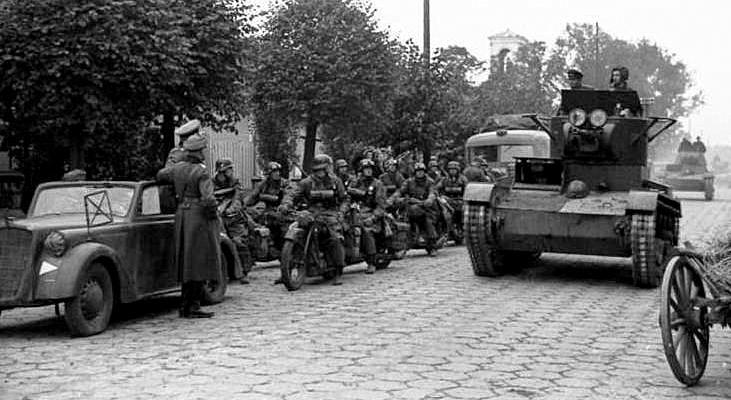 Советская танковая колонна проходит мимо группы немецких мотоциклистов