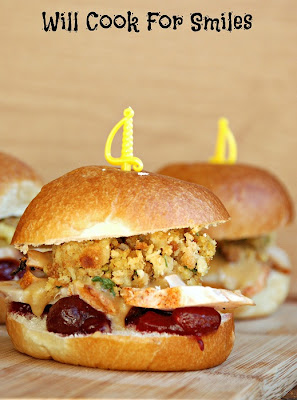 Thanksgiving Leftovers Sliders made with stuffing, turkey, and cranberries on a dinner roll with a yellow knife toothpick