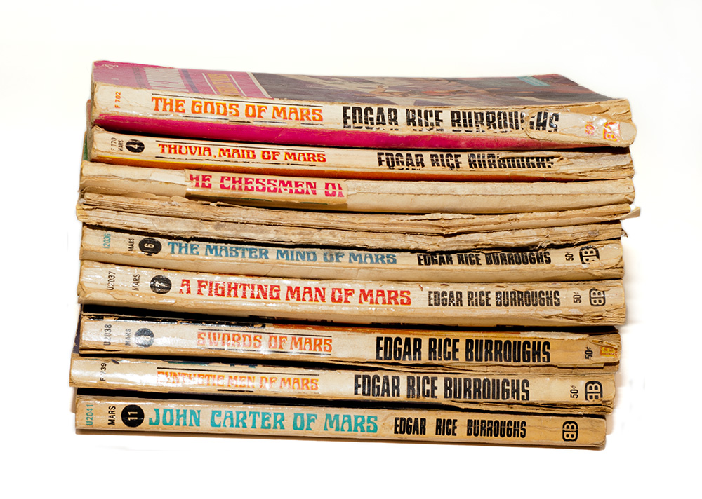 A stack of tattered paperbacks from Ballantyne Books published in the 1960s.