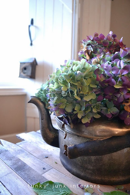 A vintage kettle becomes a flower vase for a unique wheelbarrow turned coffee table! Click to learn how!