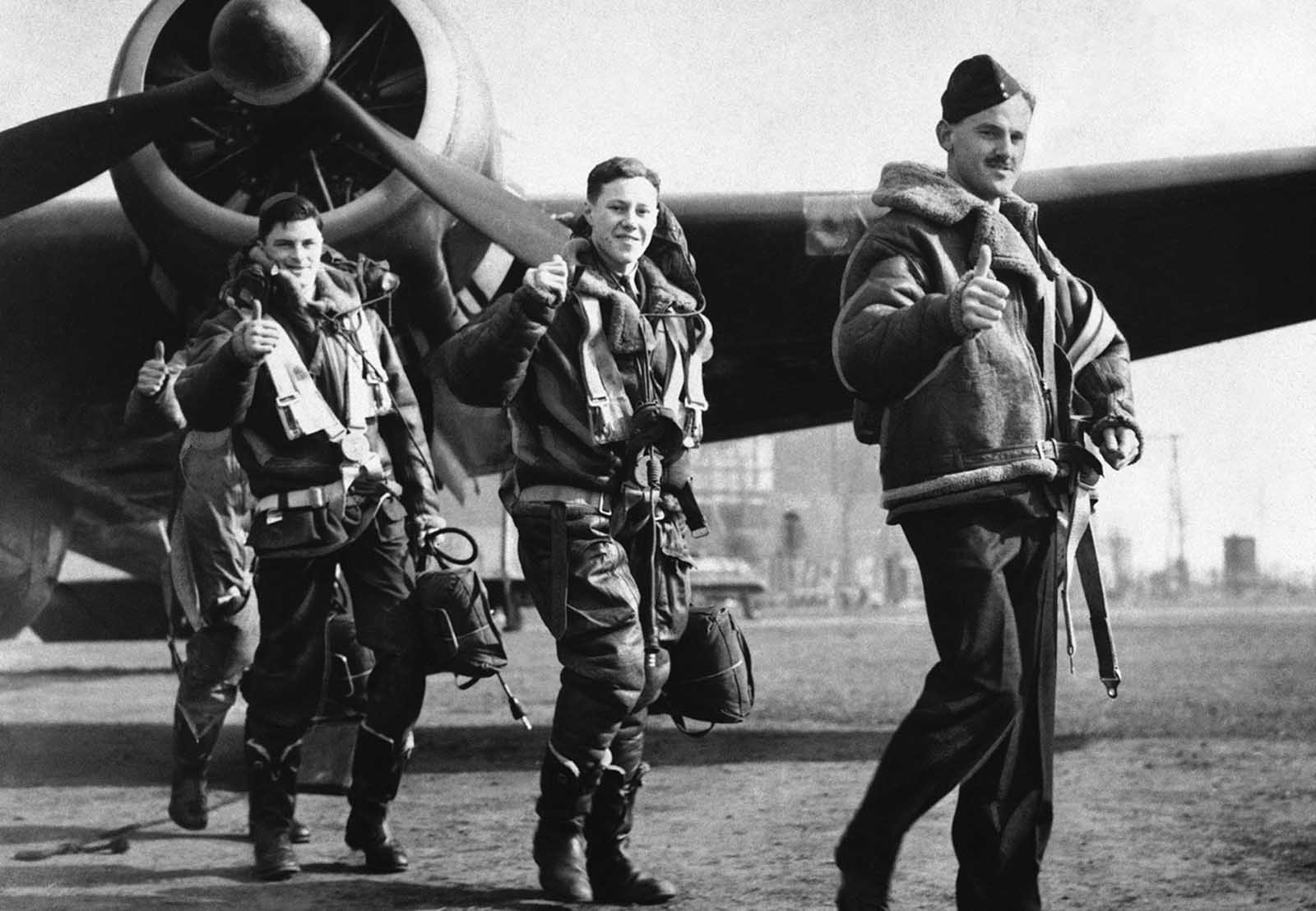 Members of a British Royal Air Force bombing squadron hold thumbs up on April 22, 1940, as they return to home base from an attack on German warships off Bergen, Norway.