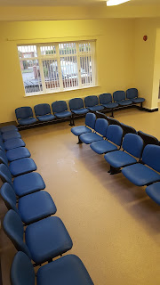 rows of beam seating upholstered in blue vinyl in a doctors waiting room