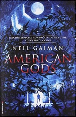Portada de la novela American Gods, de Neil Gaiman, donde se ve un bosque de noche, en un fondo azul y una luna arriba.