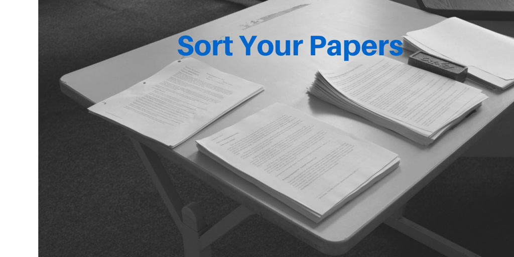Sort your papers to start organizing them stack of papers