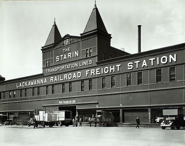 Pier 13, North River, Manhattan. April 09, 1936. Notes: Code: II.A.C.1. Lackawanna Railroad Freight station, pier 13, trucks and a wagon in front. Source: Changing New York / Berenice Abbott. Repository: The New York Public Library. Photography Collection, Miriam and Ira D. Wallach Division of Art, Prints and Photographs.