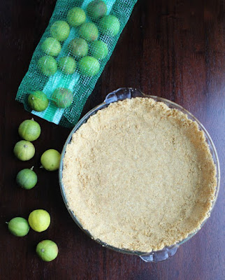 graham cracker crust in pie plate and key limes spilling out of bag