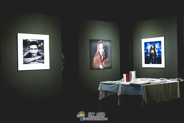 Huge portraits hanged on the wall and photobooks on the table