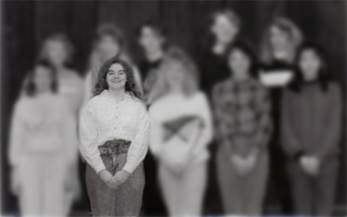 image of a black and white yearbook photo of a group of high school kids, with all of them blurred out, except for me, in the front row, looking VERY '90s