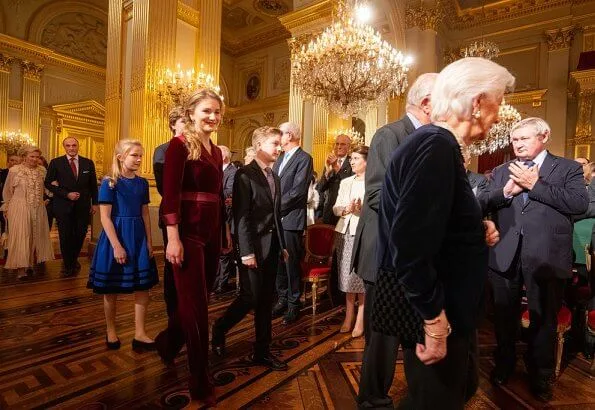 Queen Mathilde wore a floral print gown by Dries Van Noten. Crown Princess Elisabeth wore a velvet-satin jumpsuit by DVF