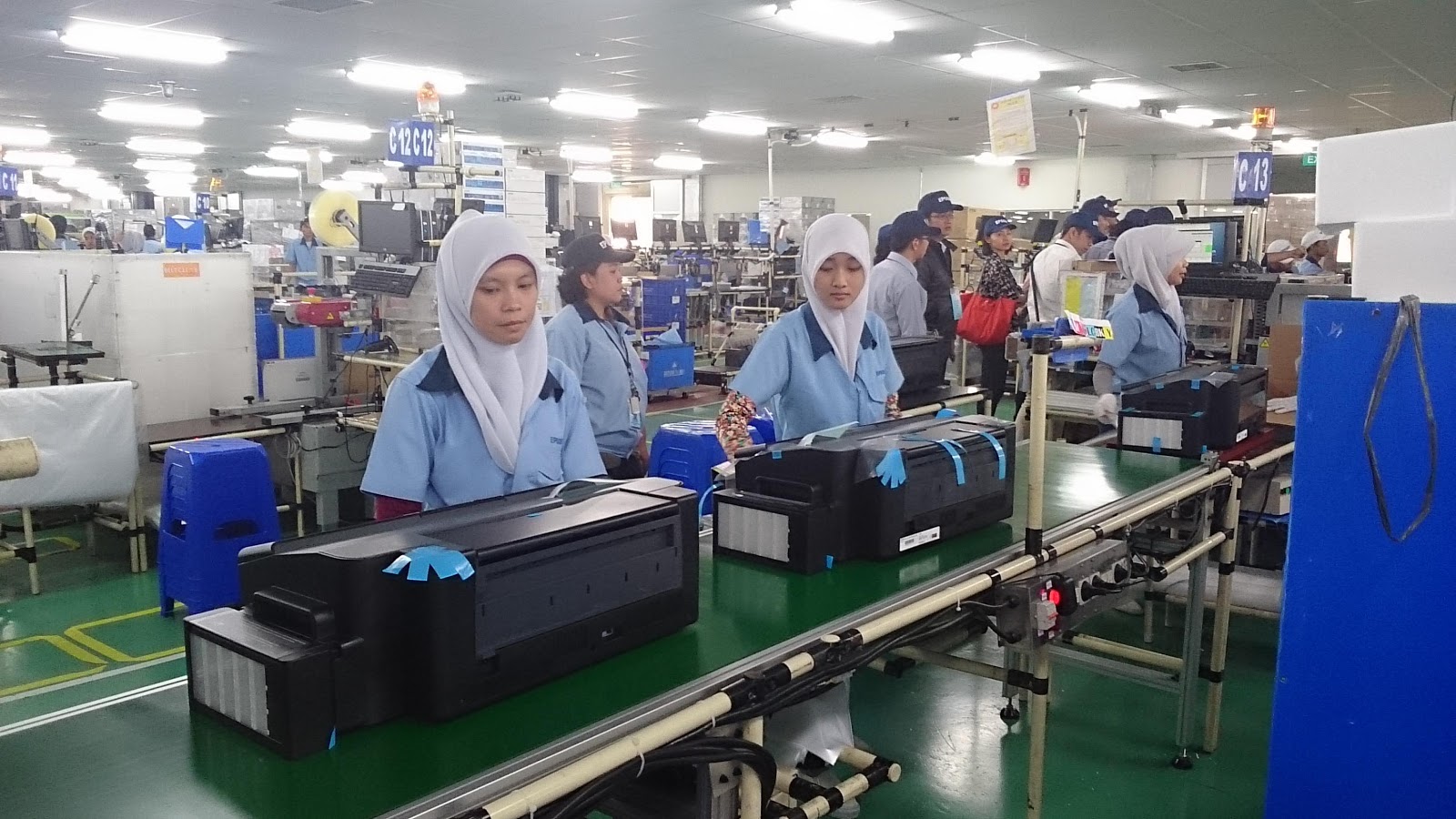  Operator produksi sedang bekerja memeriksa kualitas printer di pabrik.