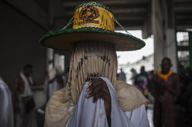 An Eyo masquerader looks on as he arrives at the Tafawa Balewa Square in Lagos on May 20, 2017. The white-clad Eyo masquerades represent the spirits of the dead and are referred to in Yoruba as “agogoro Eyo. The origins of the Eyo Festival are found in the inner workings of the secret societies of Lagos where the masquerades ensure safe passage for the spirit of Kings and notable Chiefs into the afterlife. / AFP PHOTO / STEFAN HEUNIS