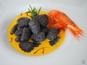 Gnocchi al nero di sepia y aroma marinero, con salsa de gambas y azafrán