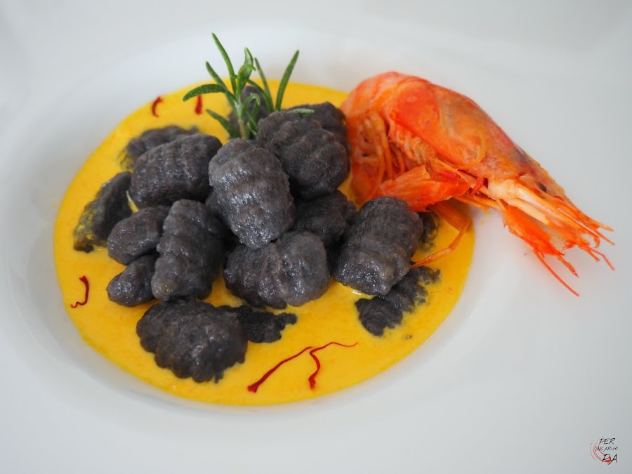 Gnocchi al nero di sepia y aroma marinero, con salsa de gambas y azafrán