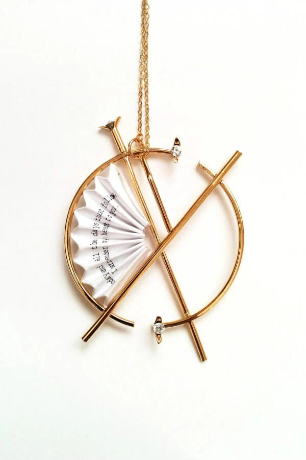 golden circular necklace with folded paper fan 